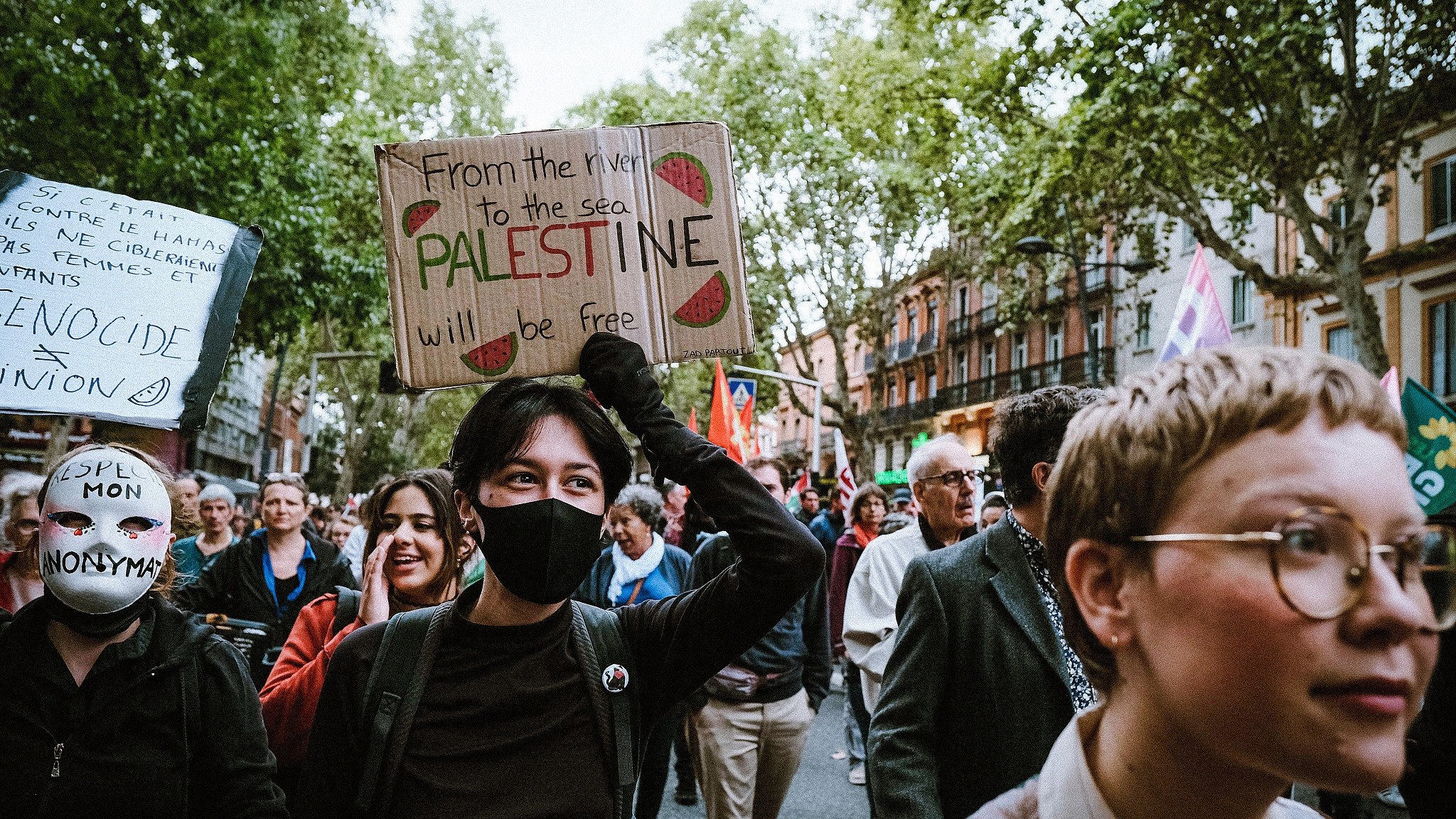 Auf einer Demo in Frankreich hält eine Person ein Plakat mit "From the River to the Sea, Palestine will be free" hoch, 11.09.2024