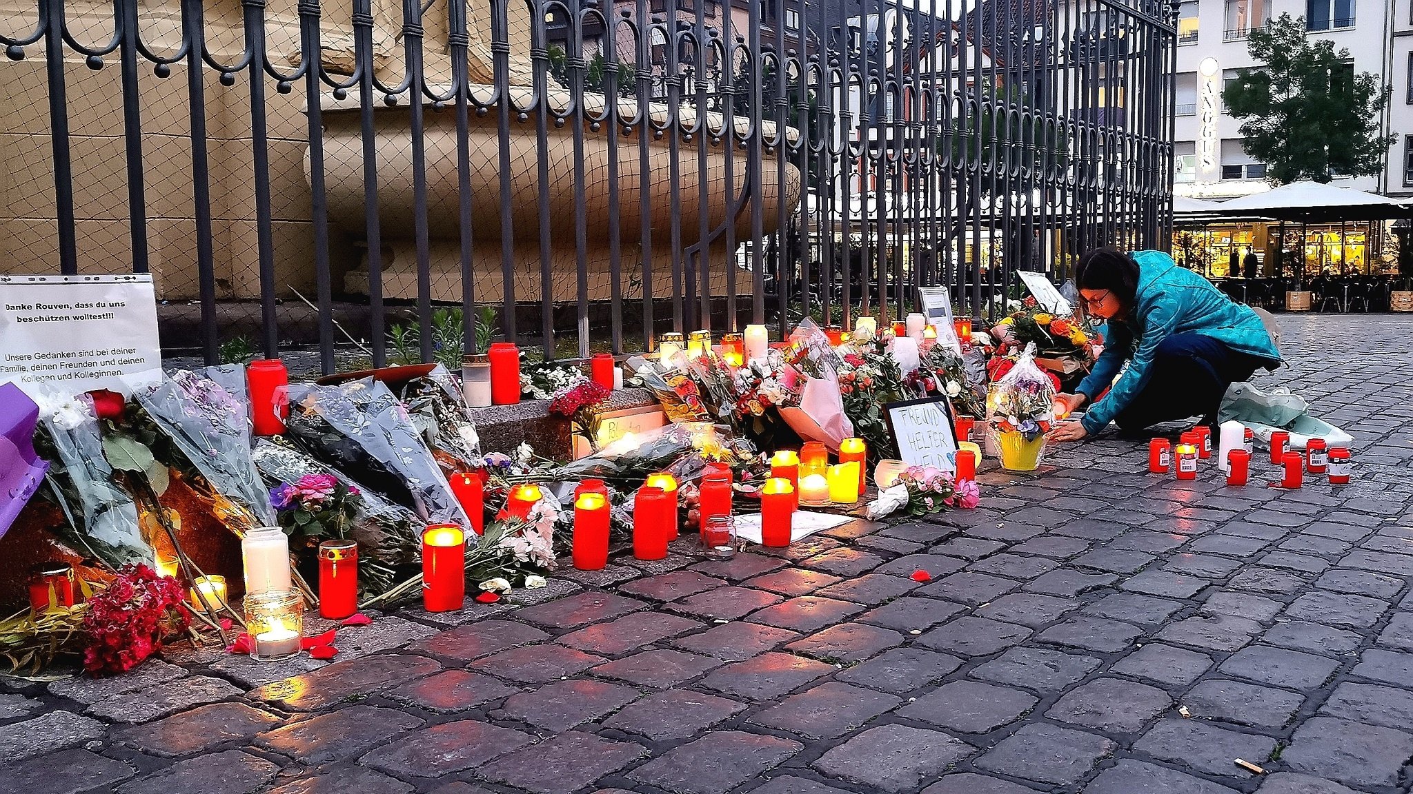 Grabkerzen, Bilder und Blumen liegen auf dem Mannheimer Marktplatz