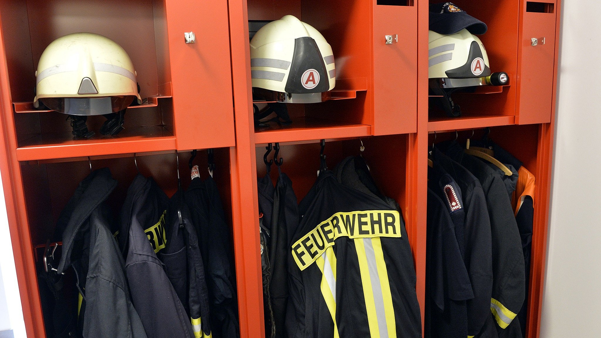 Feuerwehrkleidung und Helme in Umkleide