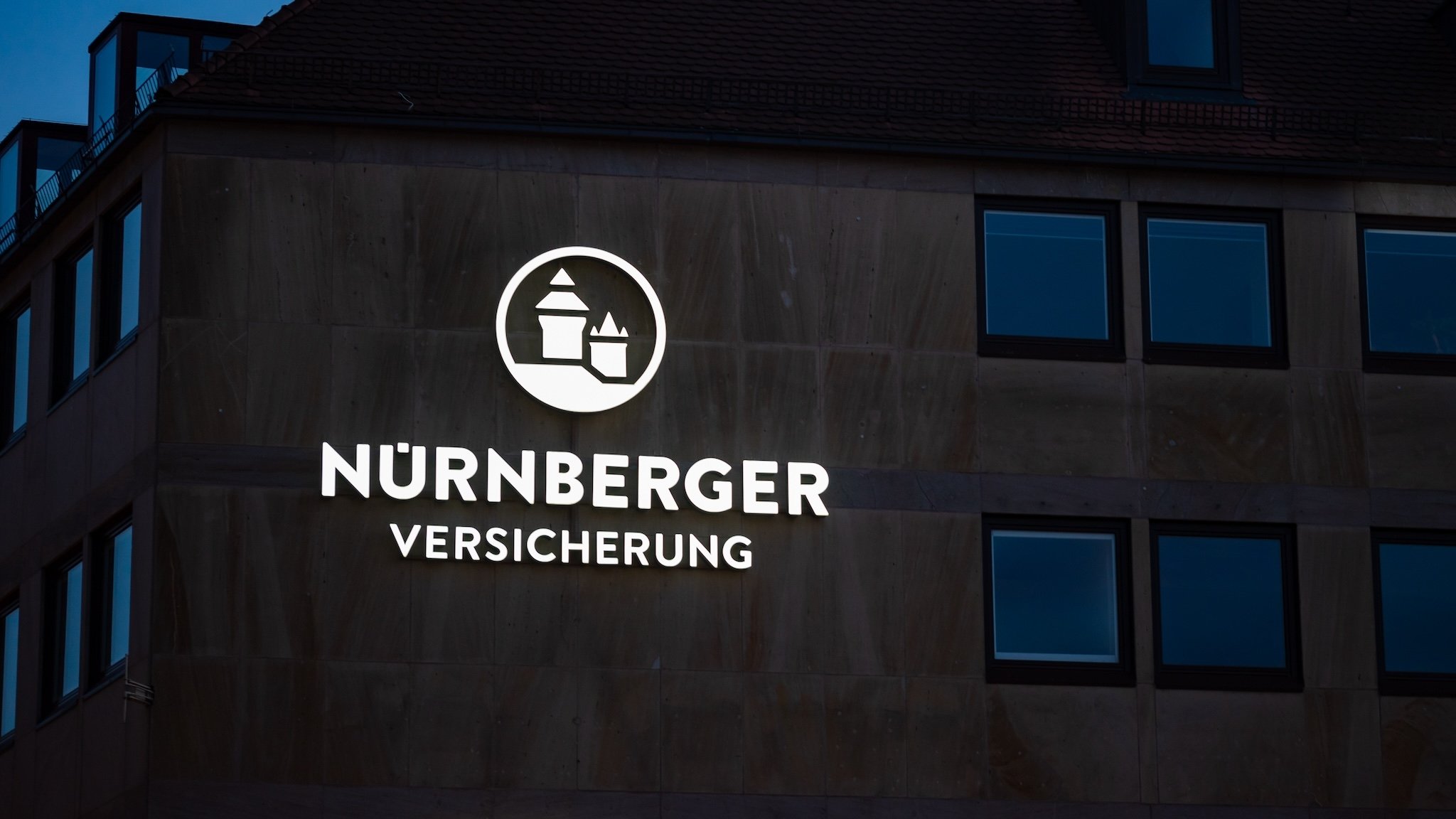 Beleuchtetes Logo Nürnberger Versicherung an Gebäudefassade