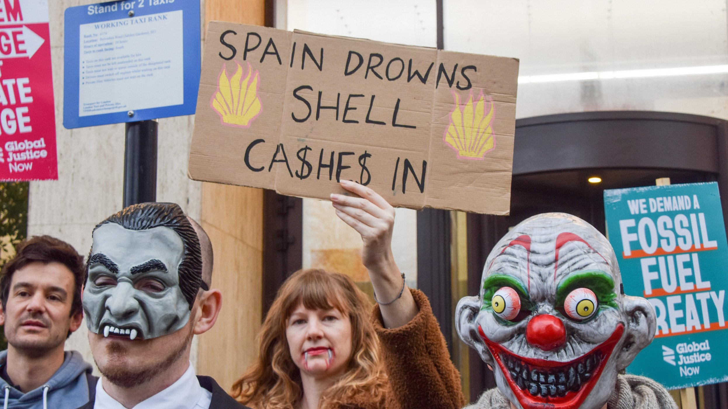 October 31, 2024, London, England, UK: A protester holds a sign referencing the floods in Spain as climate activists stage a Halloween-themed protest outside Shell headquarters