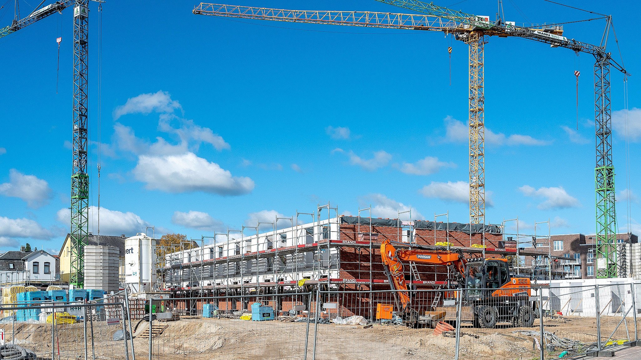 Neubauten auf einer Baustelle mit Baukränen