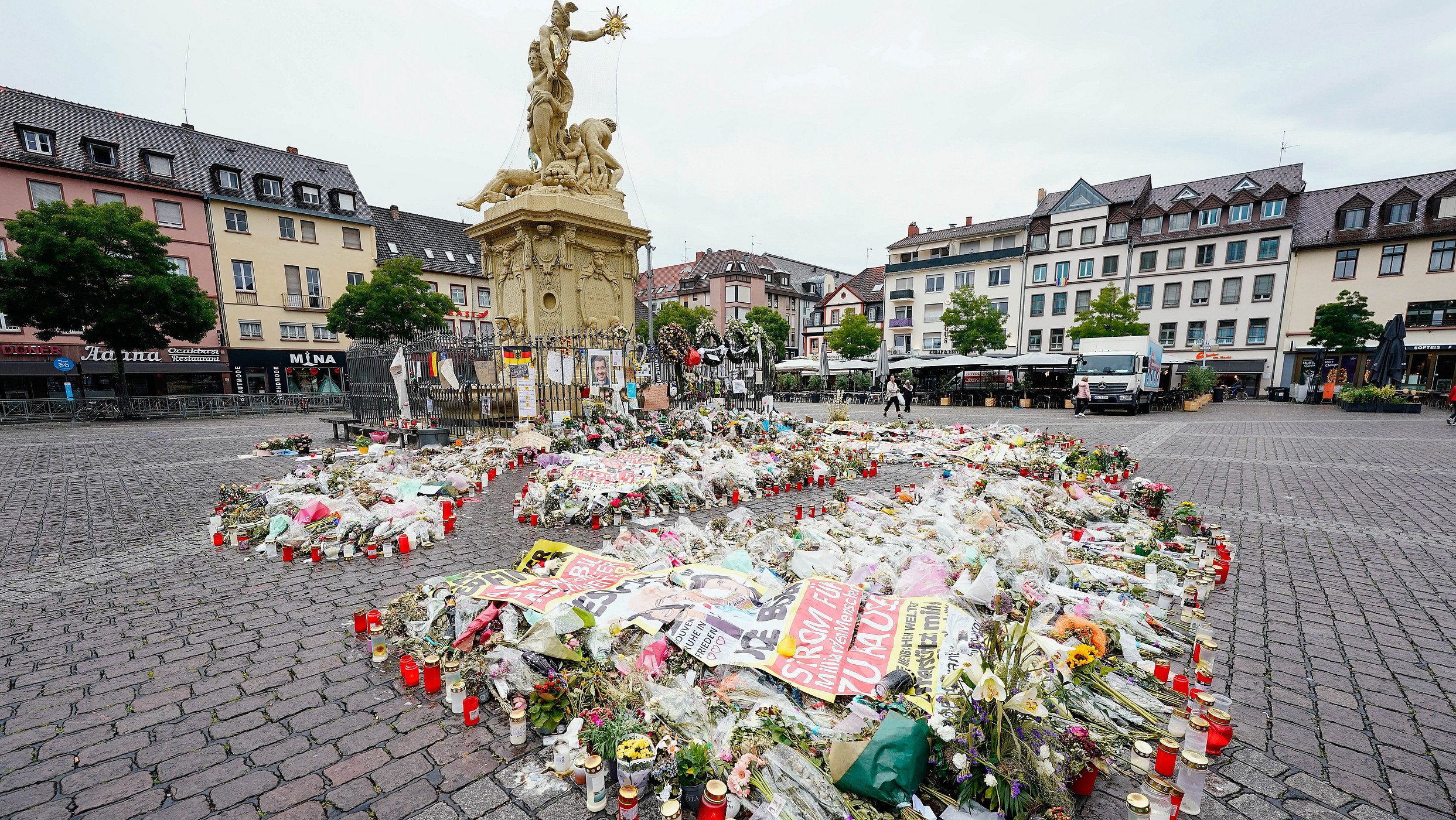 Kerzen und Blumen liegen am Maktplatz an der Trauerstelle für den getöteten Polizisten