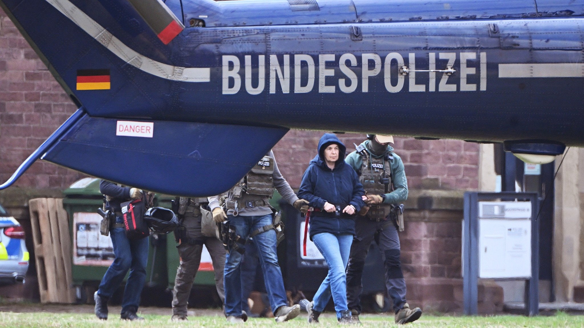 Im Innenhof eines Behördenzentrums wird die frühere RAF-Terroristin Daniela Klette zu einem Hubschrauber geführt. Zuvor hatte sie einen Haftprüfungstermin beim Bundesgerichtshof (BGH).